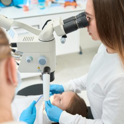Dentystka używa mikroskopu, co pokazuje skuteczność podtlenku azotu w leczeniu.