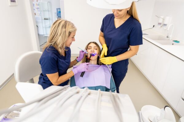 Dentystki demonstrują najnowsze metody w ortodoncji dziecięcej podczas leczenia pacjentki.